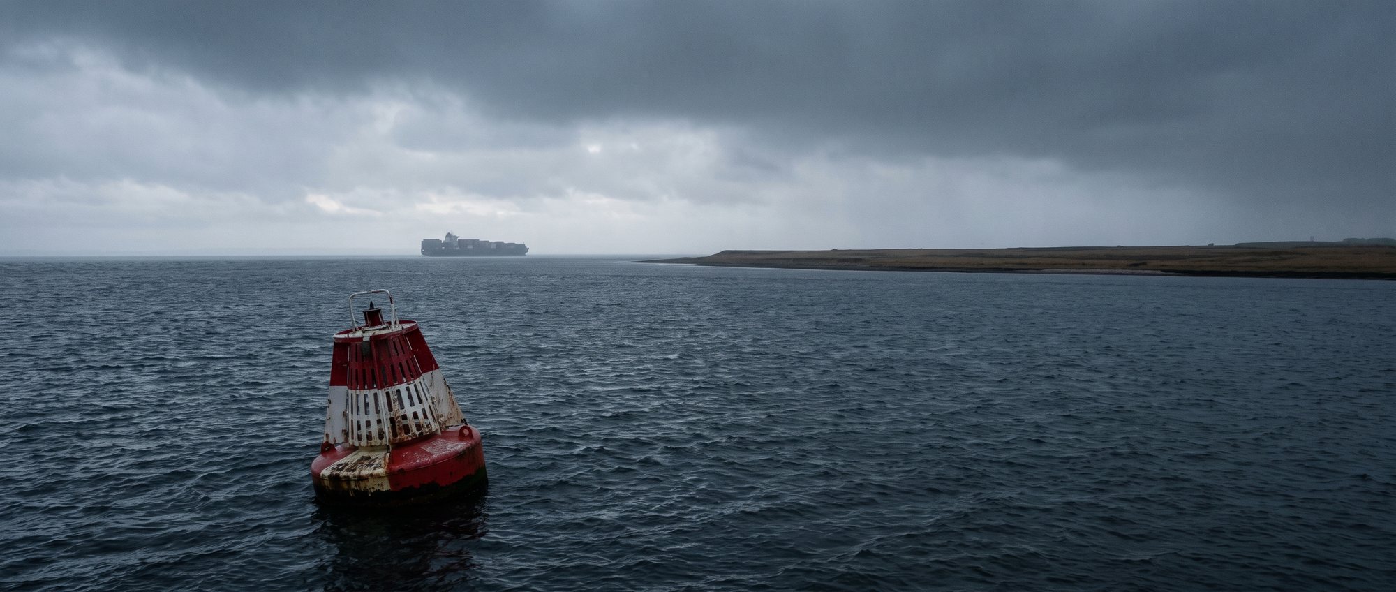 Auslaufendes Containerschiff in der Wesermündung bei grauem Wetter